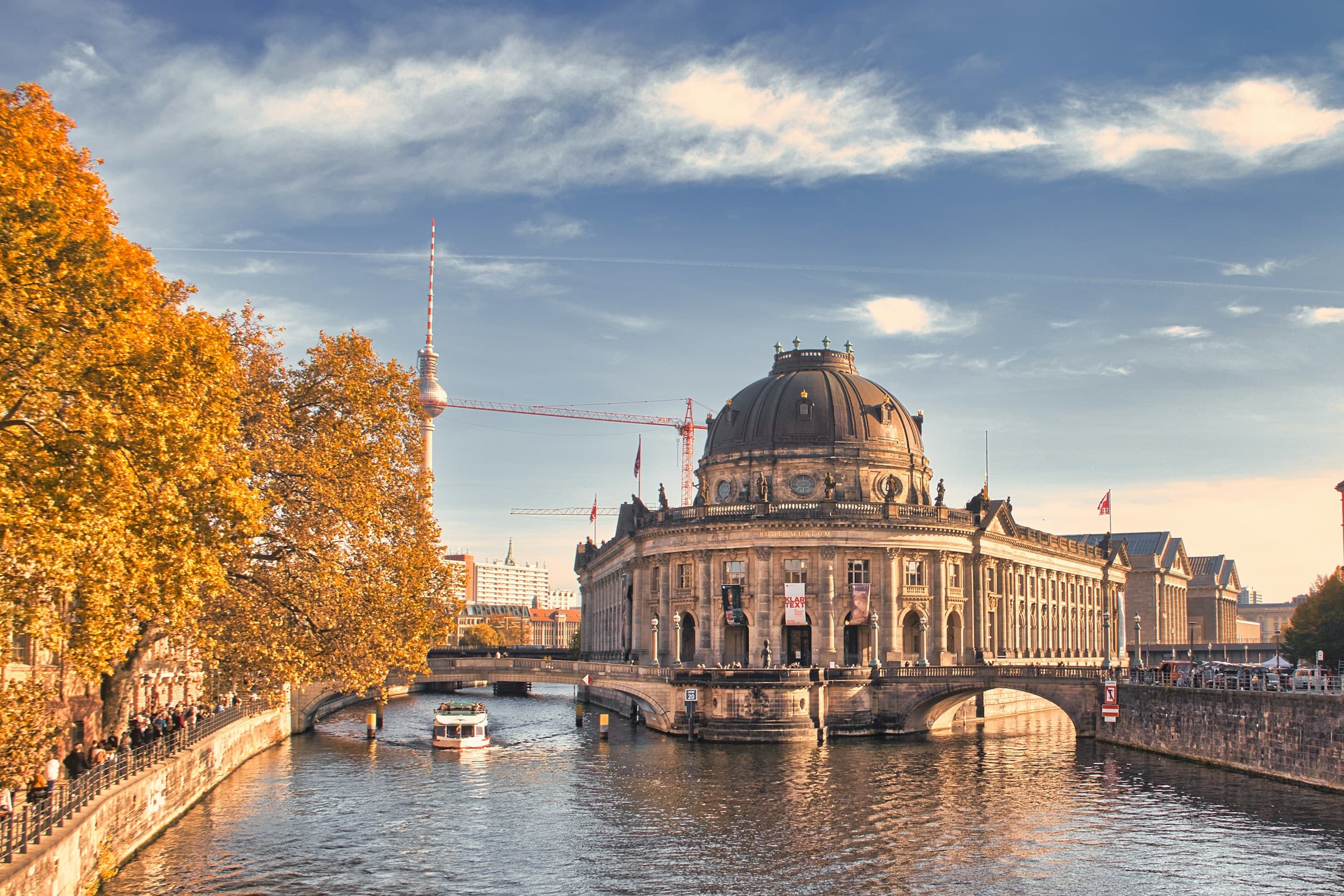 The Bode-Museum on Museum Island in autumn, its dome above the Spree with turning trees along the bank.
