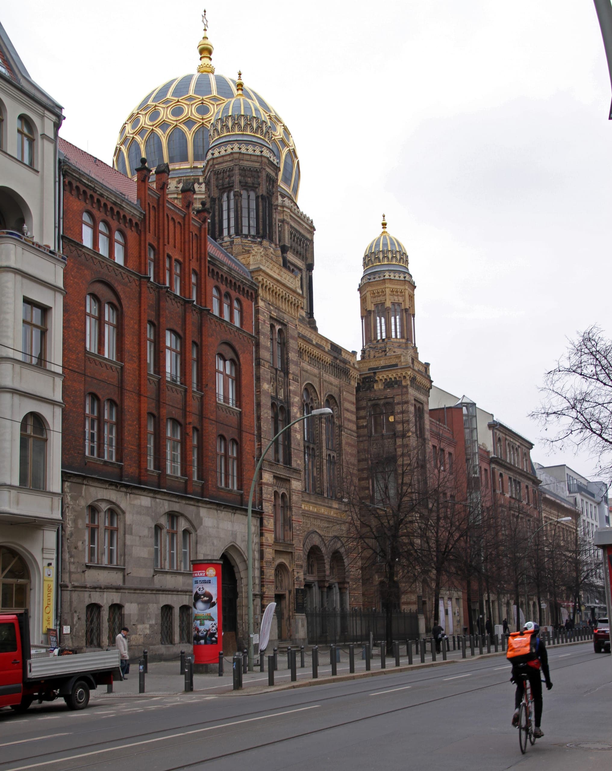 The golden dome and carved street façade of the Neue Synagoge on Oranienburger Straße, seen across the tram tracks.